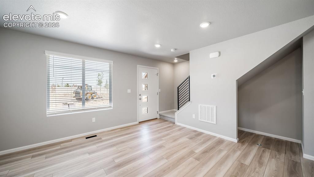 Image 20 of 28: Open-concept living area featuring wood-finish flooring and recessed lighti