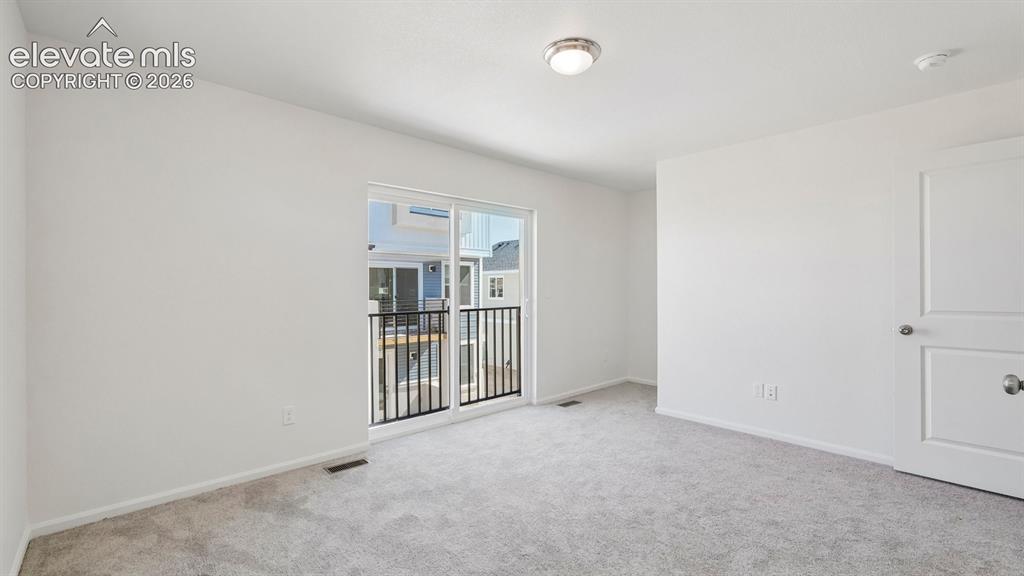 Image 22 of 28: Spacious room featuring light gray carpet flooring, a ceiling-mounted light