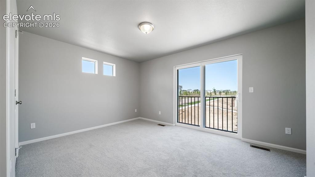 Image 25 of 28: Spacious room featuring light gray walls, plush gray carpeting, and a ceili