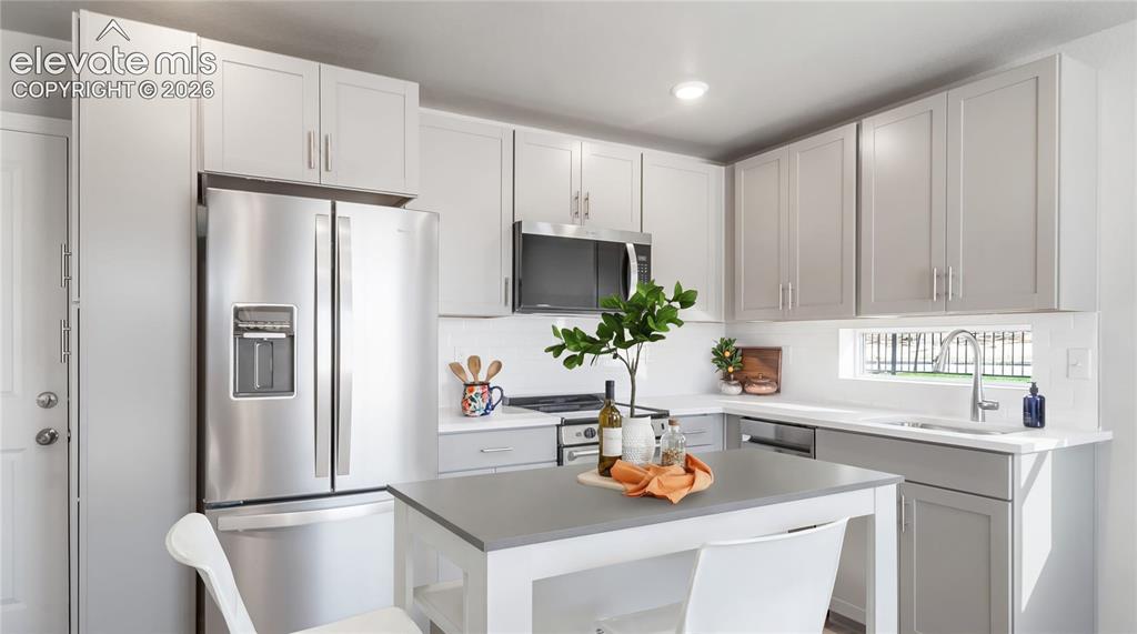 Image 3 of 28: Contemporary kitchen featuring light gray cabinetry, stainless steel applia