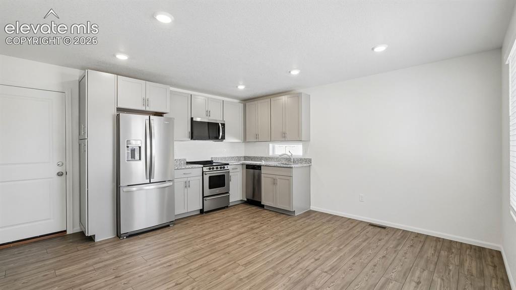 Image 7 of 28: Kitchen featuring stainless steel appliances, light-toned cabinetry, granit