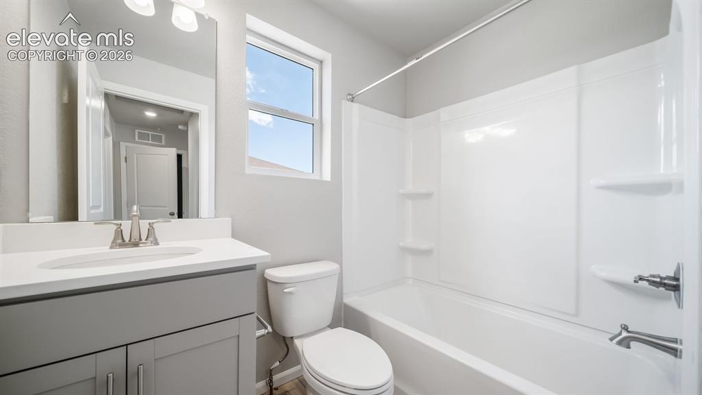 Image 8 of 28: Full bathroom featuring a single vanity with gray cabinetry, white countert