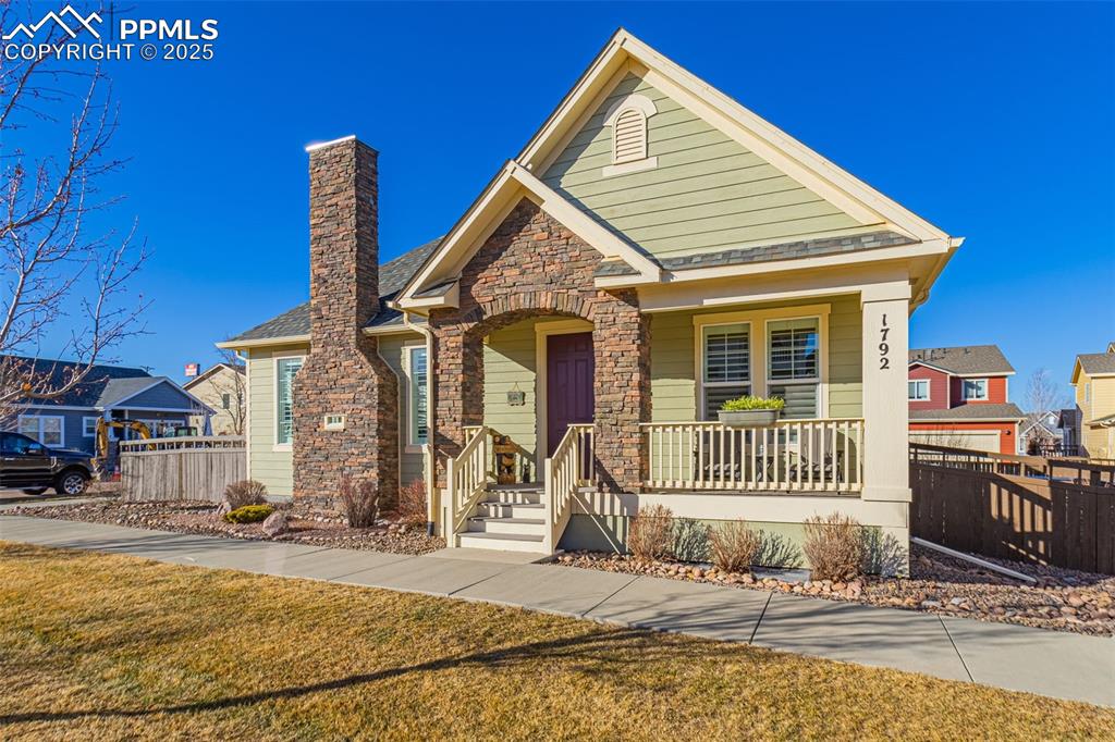 Caption: View of front of house with a porch and a front yard