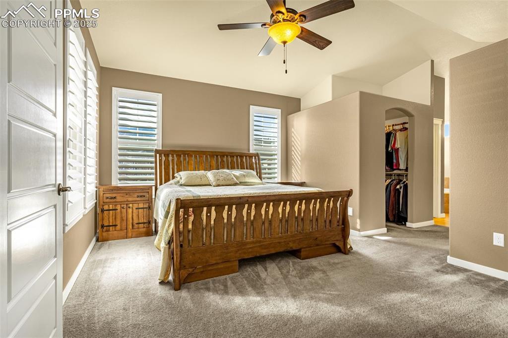 Image 11 of 42: Carpeted bedroom featuring lofted ceiling, a walk in closet, a closet, and