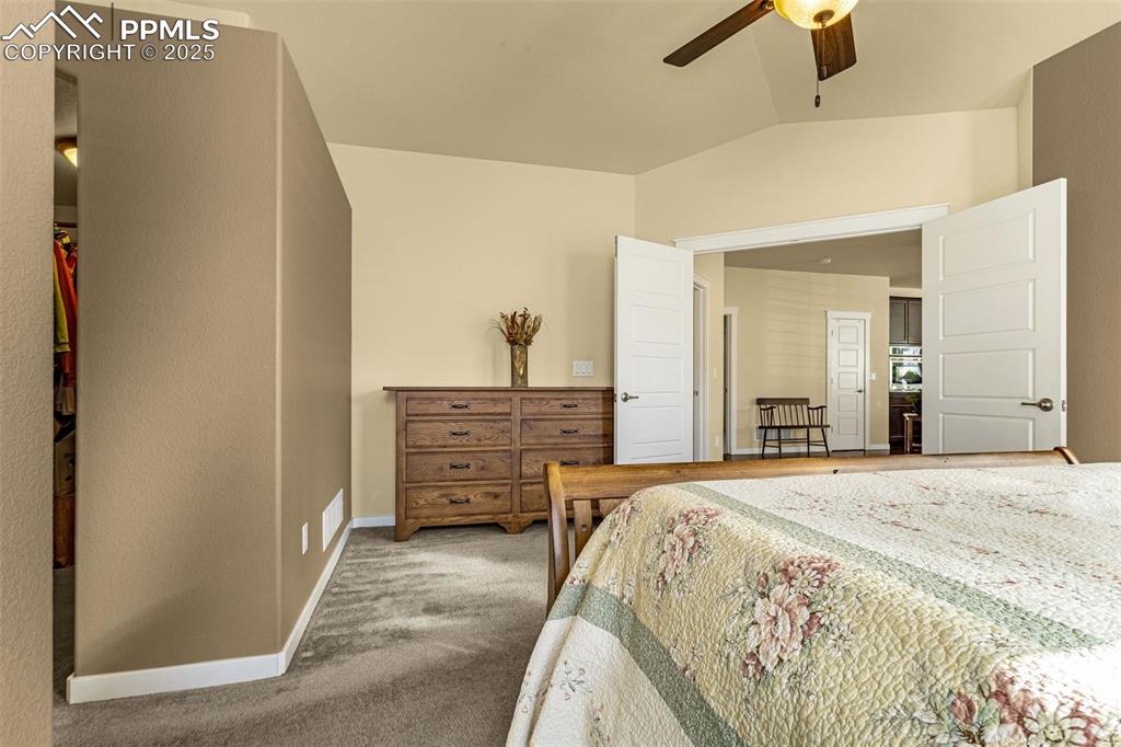 Image 12 of 42: Bedroom featuring vaulted ceiling, carpet floors, and ceiling fan