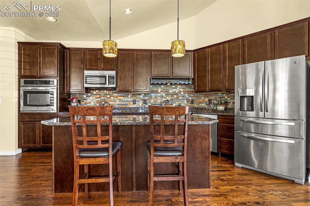 Image 2 of 42: Kitchen with appliances with stainless steel finishes, decorative light fix