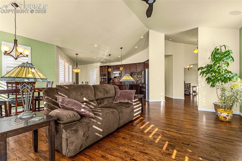 Image 5 of 42: Living room featuring an inviting chandelier, dark hardwood / wood-style fl