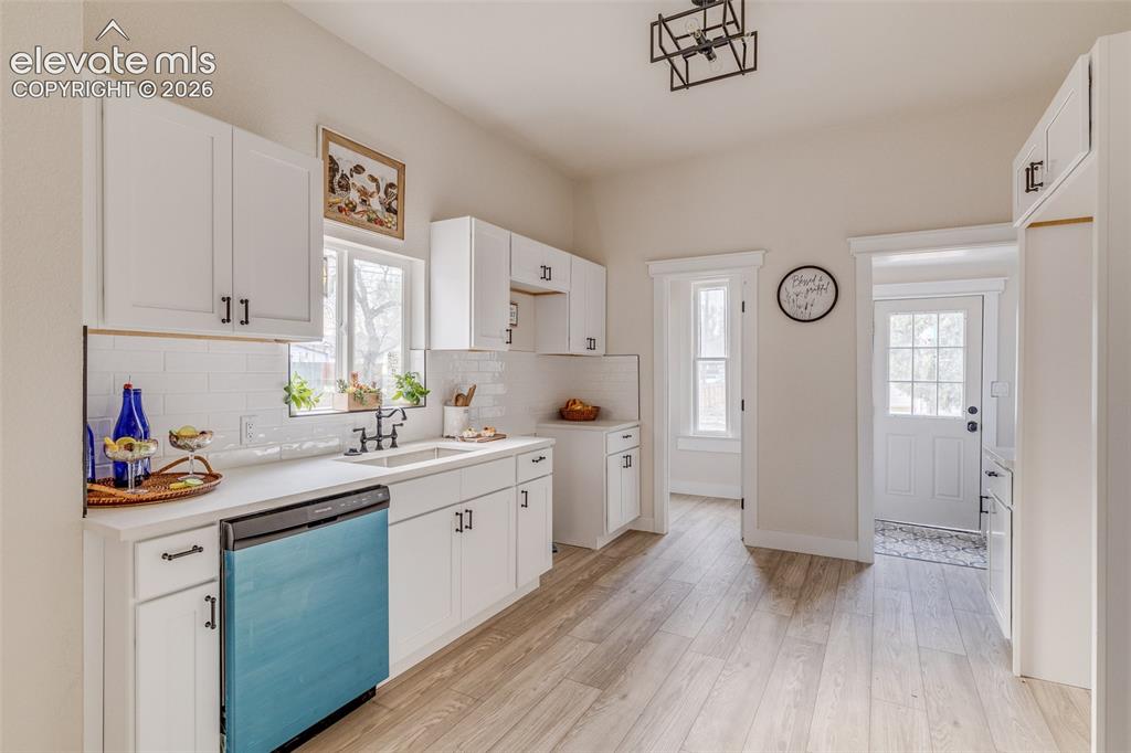 Image 19 of 27: Kitchen featuring white shaker cabinetry, light wood-finish flooring, white