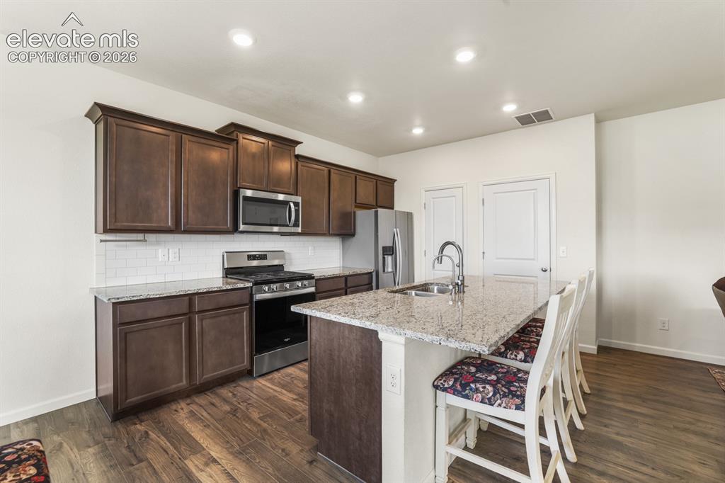 Image 13 of 42: The Living Room flows seamlessly into the Kitchen and Dining Area.