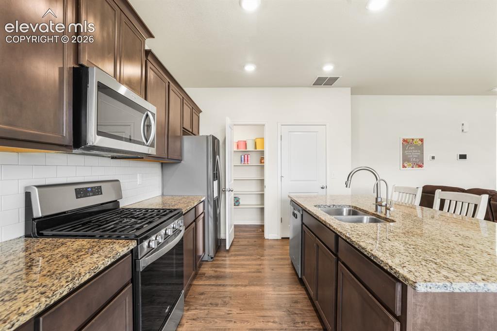 Image 17 of 42: The Island Kitchen has wood cabinets and beautiful granite countertops.