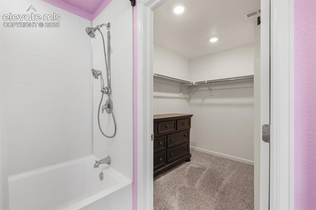 Image 29 of 42: Upper Level Primary Bedroom with neutral carpet, custom paint tones, and ad