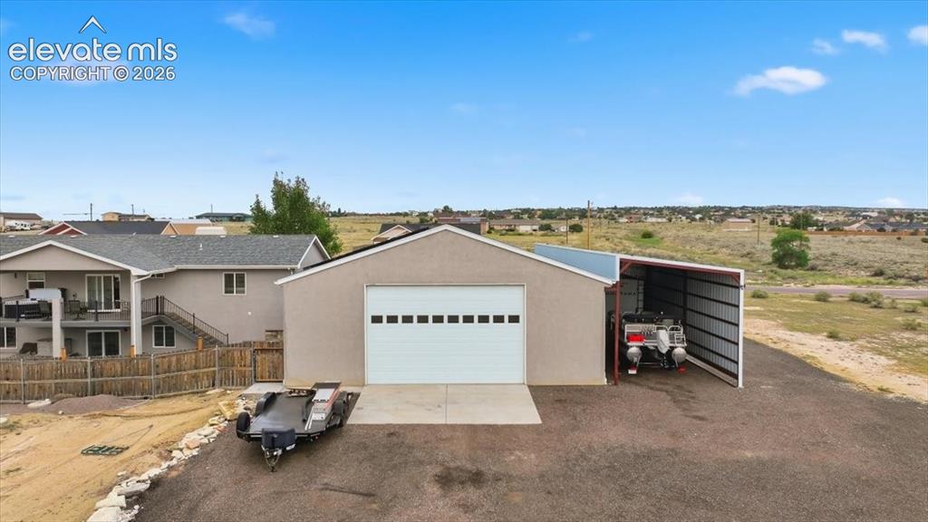 Image 8 of 50: Back of garage with road and oversized garage door.