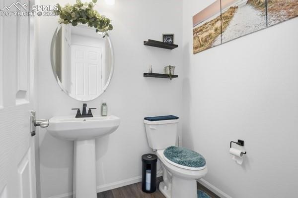 Image 11 of 36: Bathroom featuring toilet and dark wood-type flooring