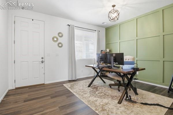 Image 29 of 36: Office area with a decorative wall and dark wood finished floors