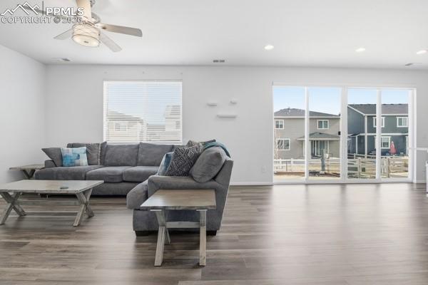 Image 4 of 36: Living area with dark wood finished floors and a ceiling fan