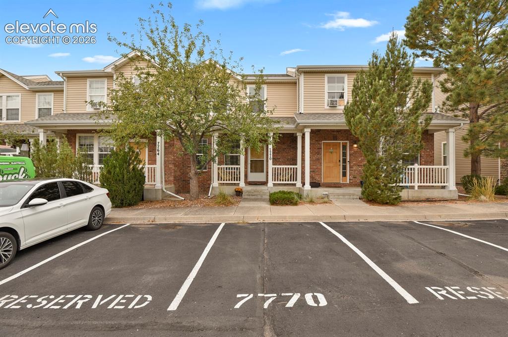 Image 7 of 34: Front of the home with designated parking and porch