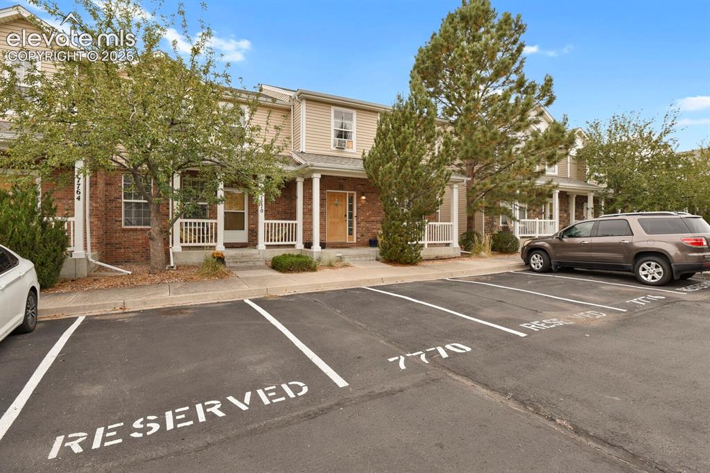 Image 8 of 34: Front of the home with designated parking and porch
