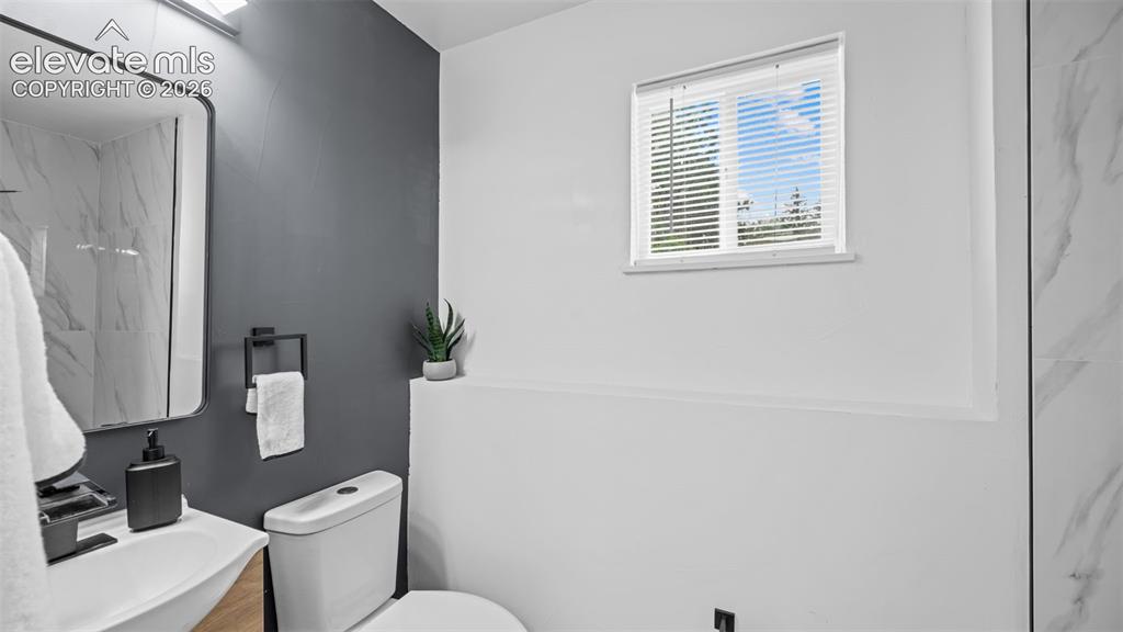 Image 15 of 21: Bathroom featuring a modern vanity with a rectangular sink, wall-mounted fa