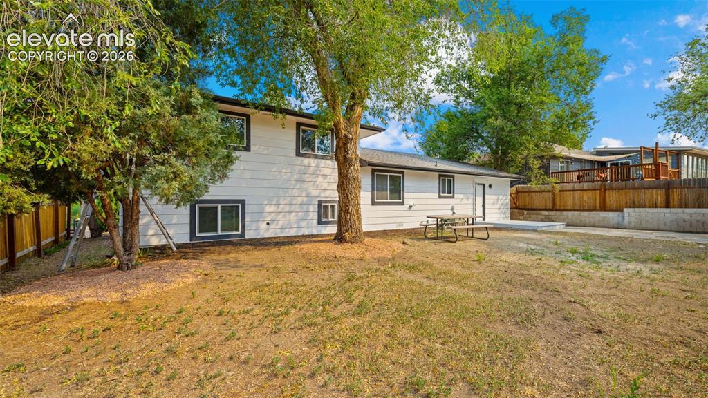 Image 21 of 21: Multi-level residence featuring white siding with contrasting dark trim, a 