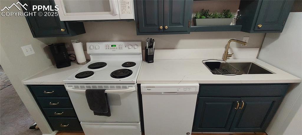 Image 17 of 46: Kitchen with white appliances and a sink