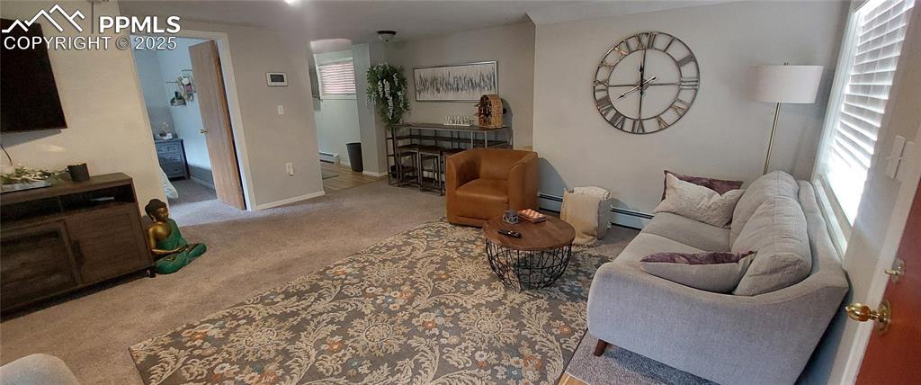 Image 5 of 46: Living area featuring carpet floors and baseboard heating