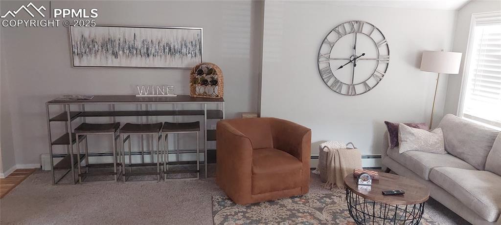 Image 6 of 46: Carpeted living area featuring a baseboard radiator and baseboard heating