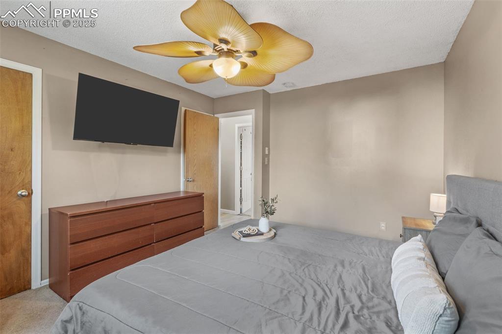 Image 16 of 29: Bedroom featuring carpet, a ceiling fan, and a textured ceiling
