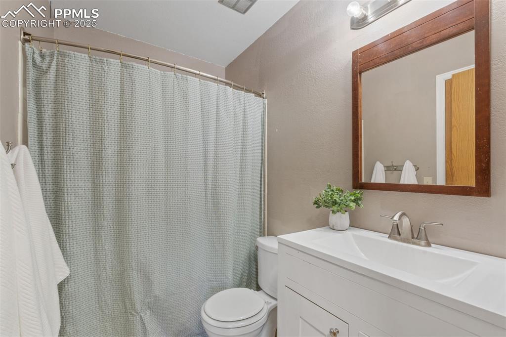 Image 17 of 29: Bathroom featuring vanity, a shower with curtain, and a textured wall