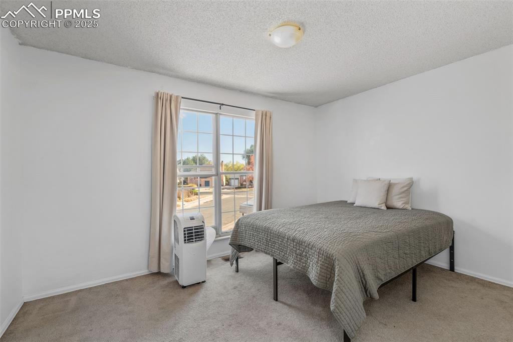 Image 18 of 29: Bedroom featuring light carpet and a textured ceiling