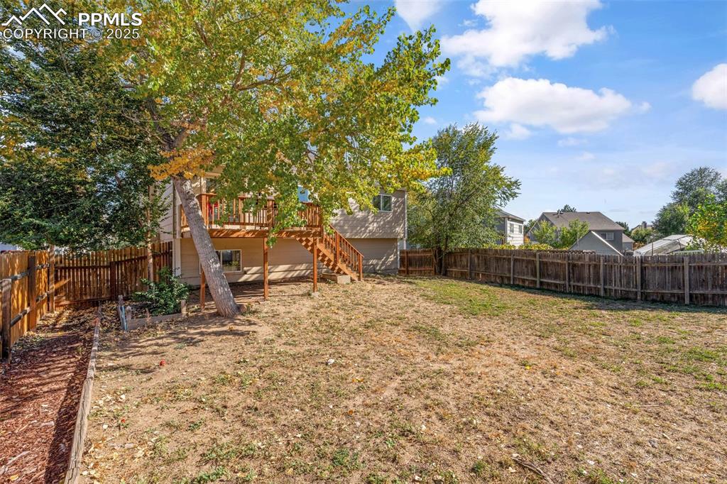 Image 28 of 29: Fenced backyard with a deck