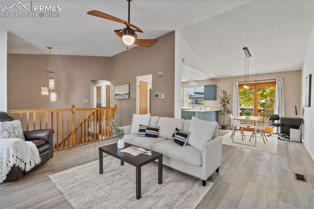 Image 7 of 29: Living area with light wood finished floors, a textured ceiling, a ceiling