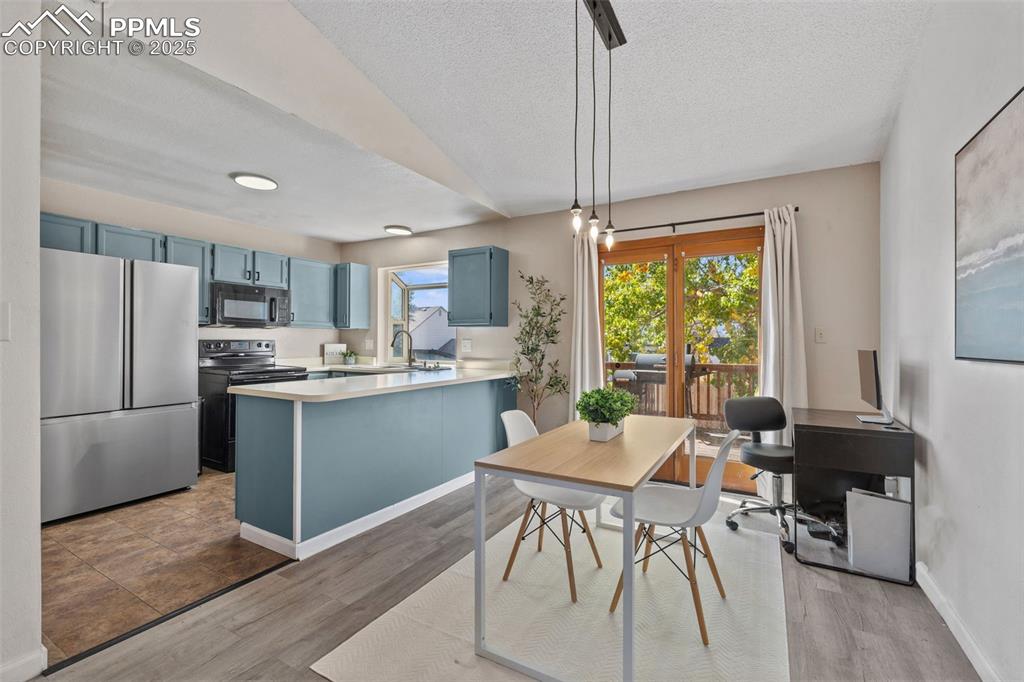 Image 9 of 29: Dining space with a textured ceiling, light wood-style floors, and a desk