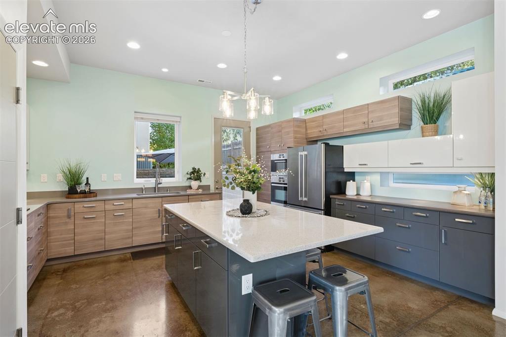 Image 18 of 45: Three tone slab-faced cabinetry 