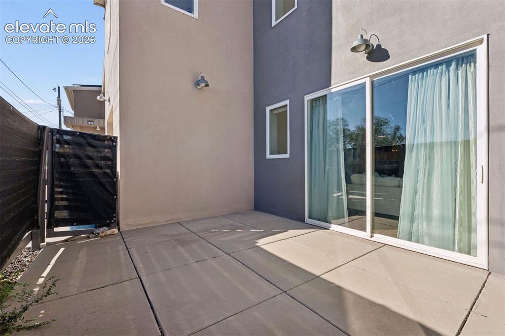 Image 9 of 45: East side patio is fenced in for privacy and walks into the living room
