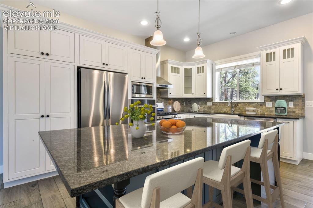 Image 11 of 50: Incredible kitchen with island virtually staged