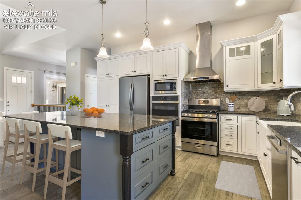 Image 13 of 50: Incredible kitchen with island virtually staged