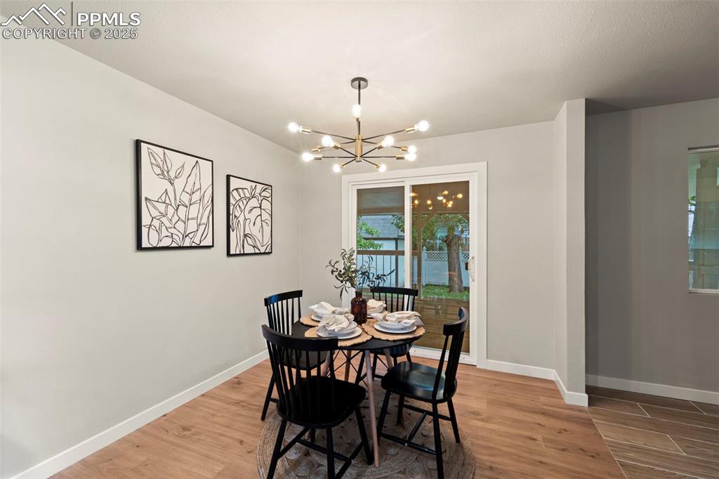 Image 12 of 31: Dining area featuring a chandelier, wood finished floors, and baseboards
