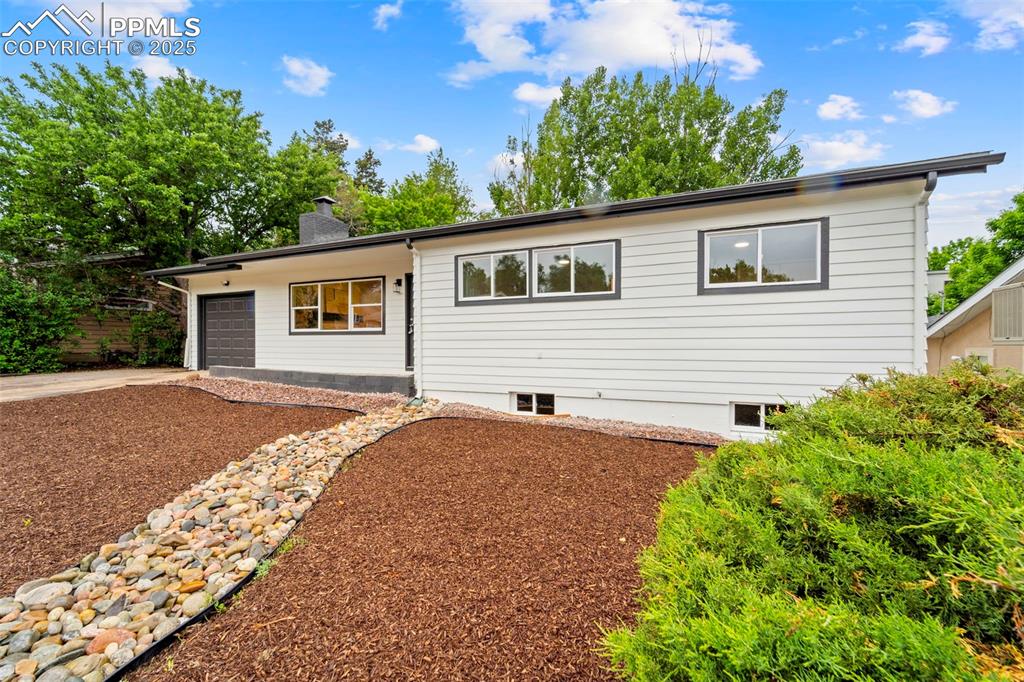 Image 2 of 31: Ranch-style home with a garage, driveway, and a chimney