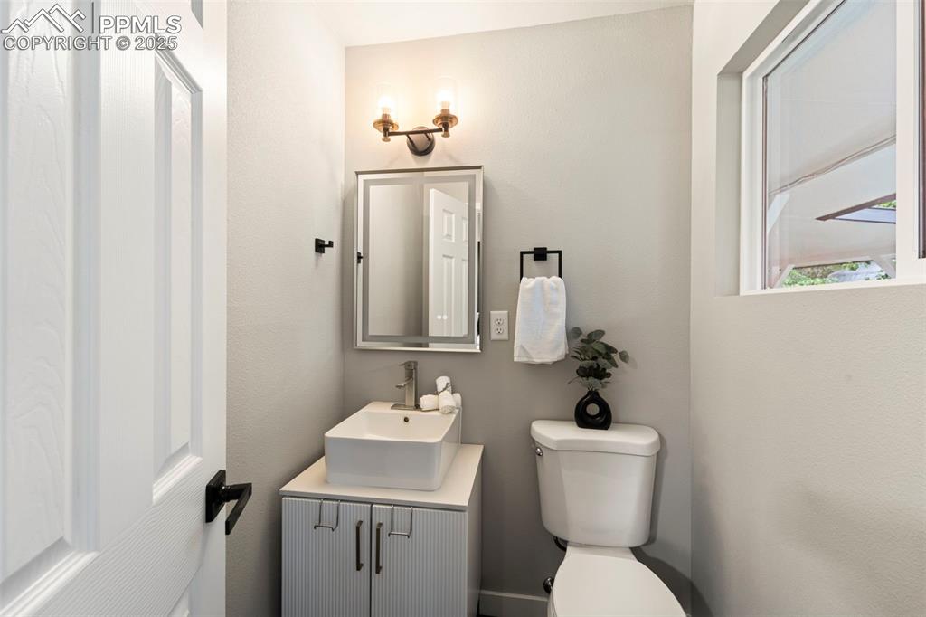 Image 20 of 31: Half bath with vanity and toilet