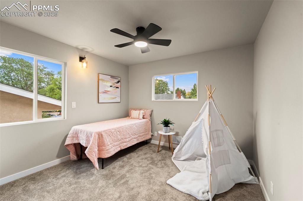 Image 22 of 31: Bedroom with multiple windows, baseboards, carpet flooring, and ceiling fan