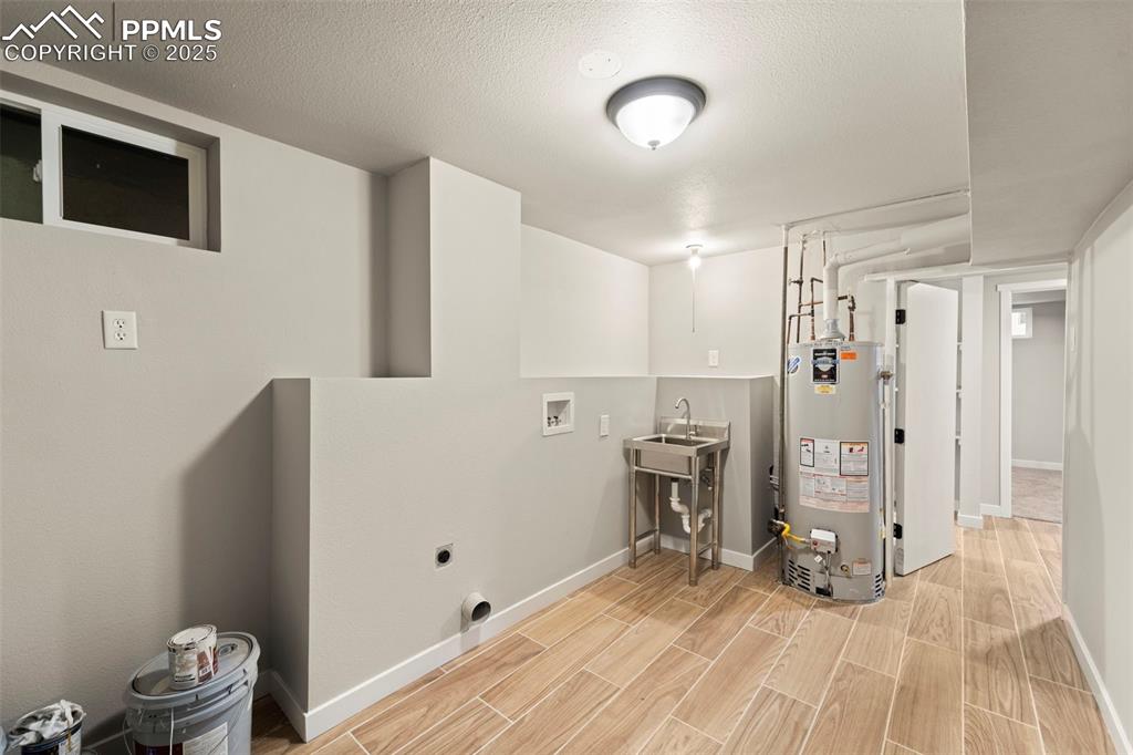 Image 25 of 31: Washroom with gas water heater, washer hookup, hookup for an electric dryer