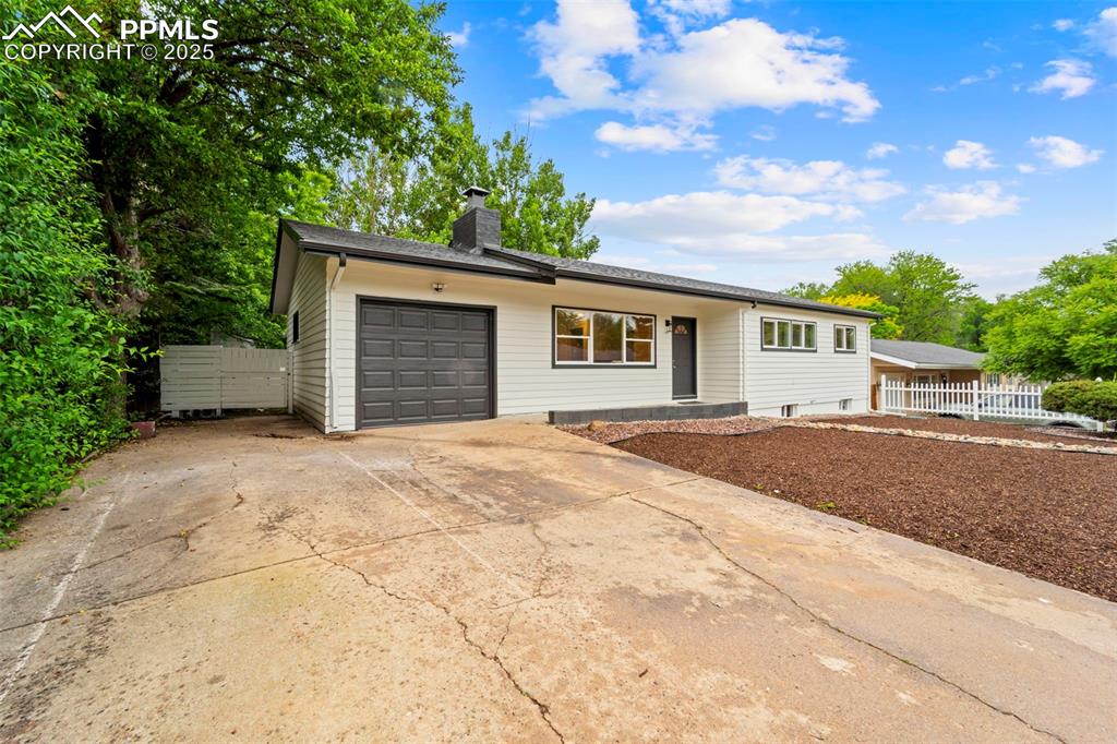 Image 3 of 31: View of front of house with a garage, a chimney, and concrete driveway