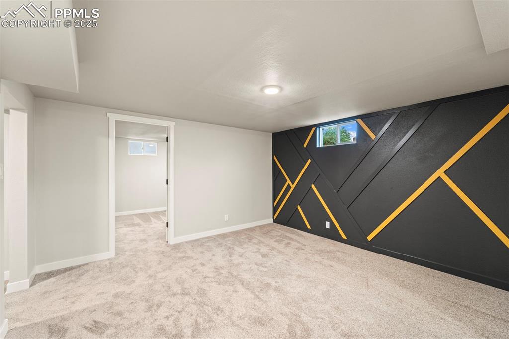 Image 31 of 31: Below grade area featuring carpet floors, baseboards, and plenty of natural