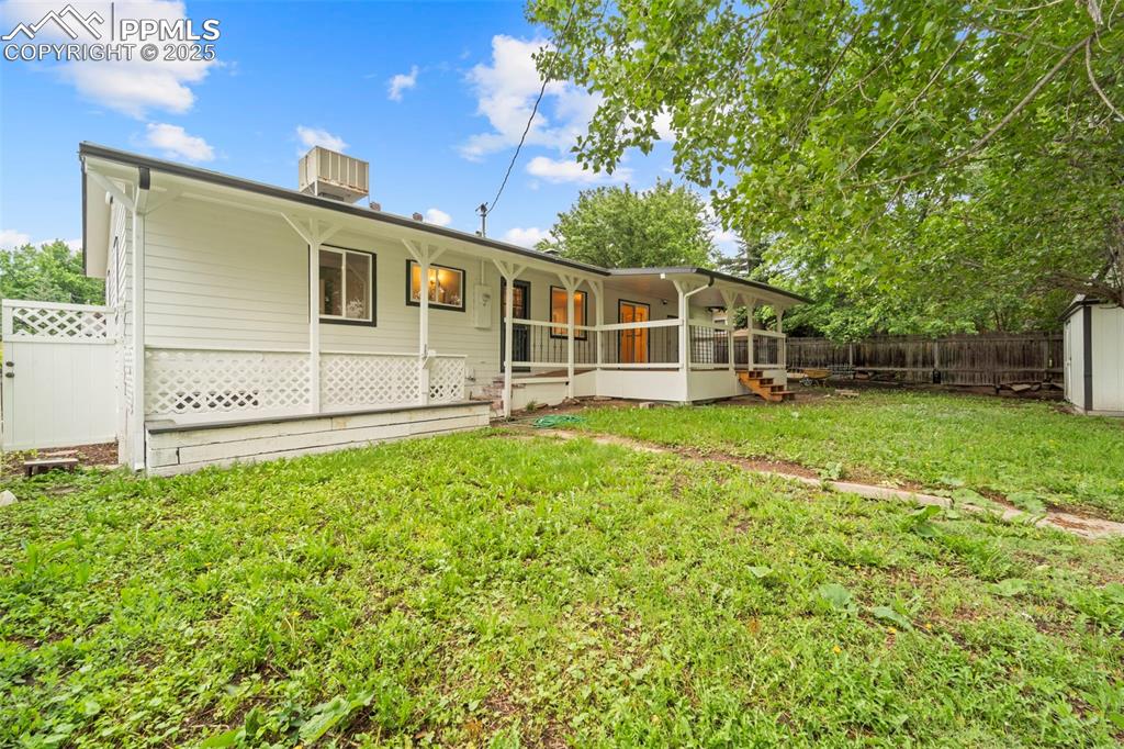 Image 6 of 31: Rear view of house featuring central AC unit and covered porch