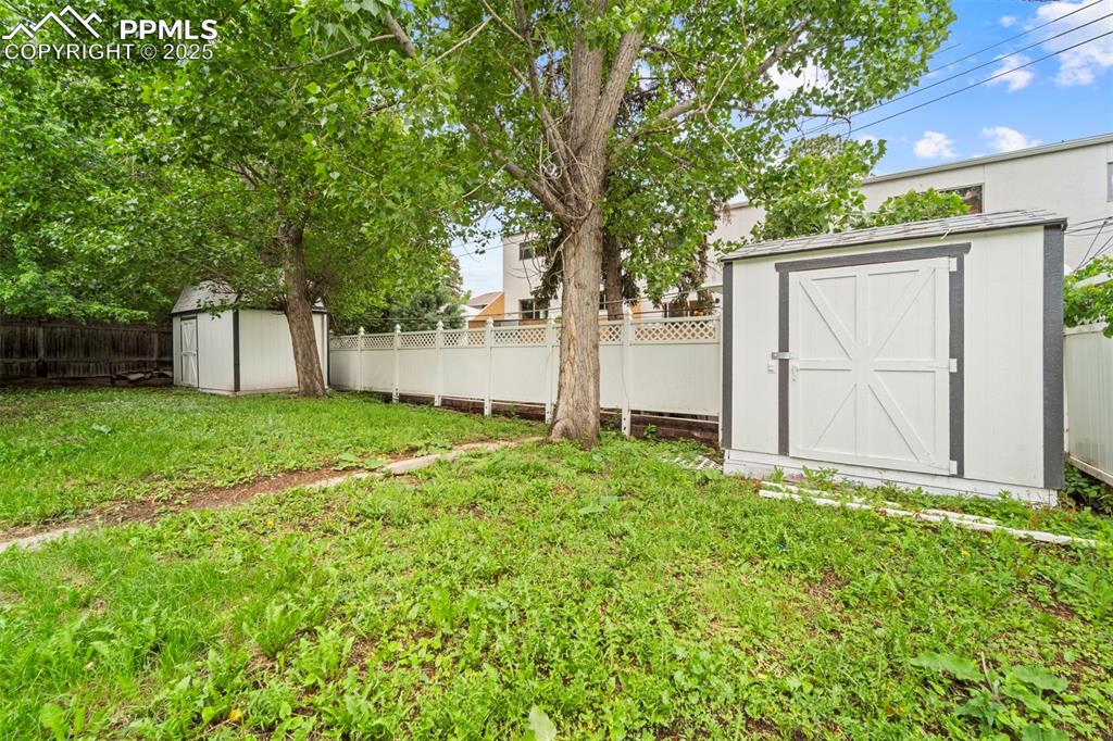 Image 7 of 31: View of yard, with two sheds for storage
