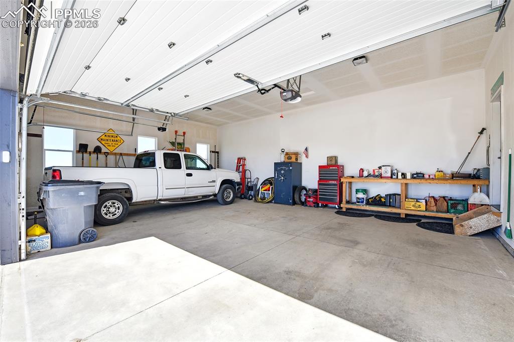 Image 4 of 49: Large 3-Car Garage with Workbench and Gun Safe