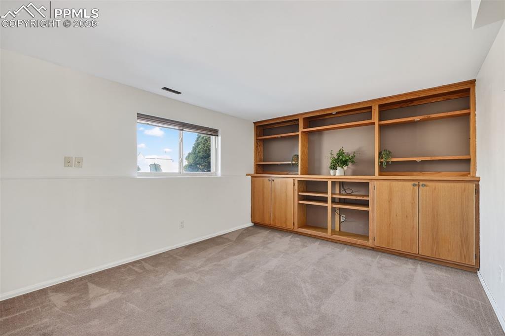 Image 13 of 26: Retreat to the family room entertainment oasis with beautiful oak built-ins