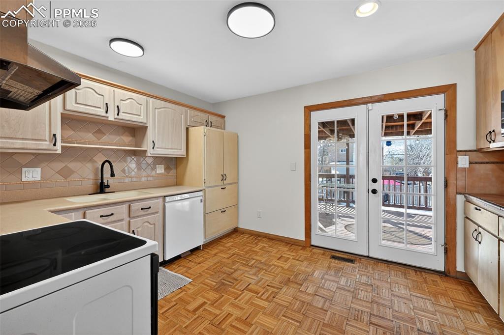 Image 6 of 26: Kitchen features ample cabinet and counter space and walks out to the cover