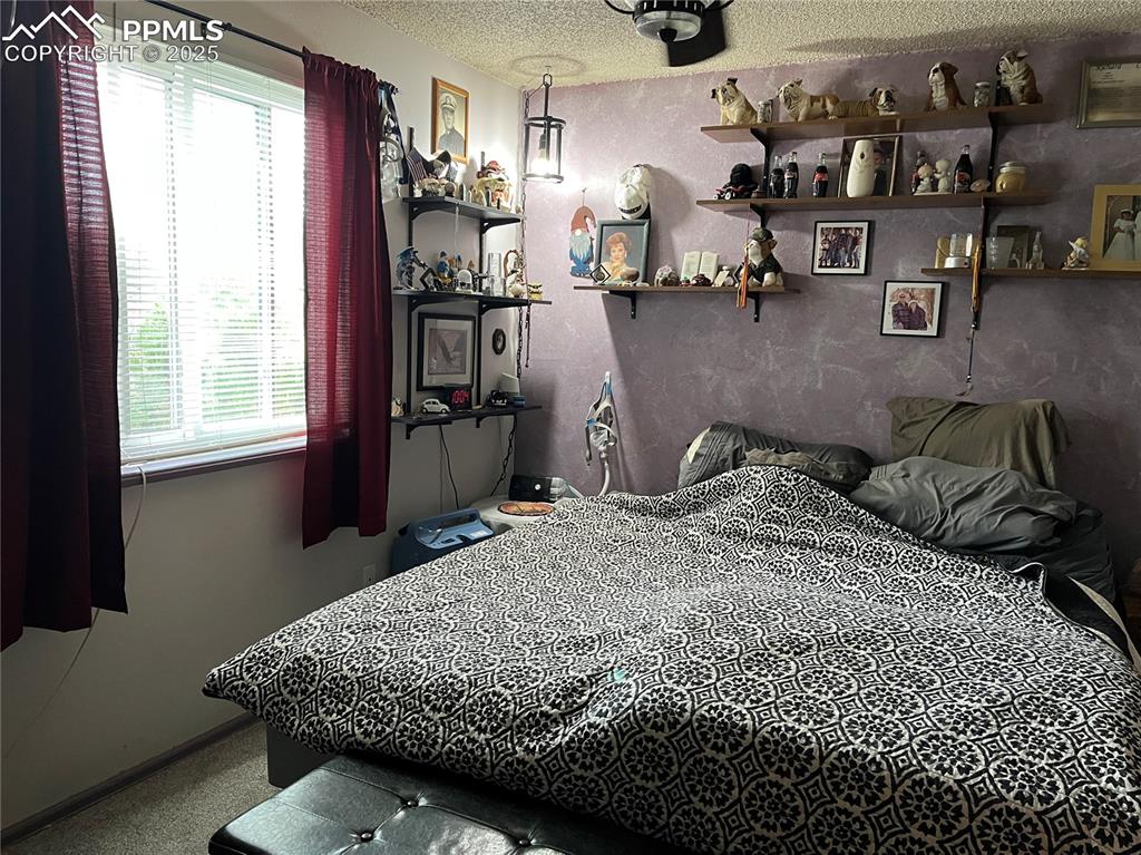 Image 13 of 17: Bedroom with a textured ceiling and baseboards