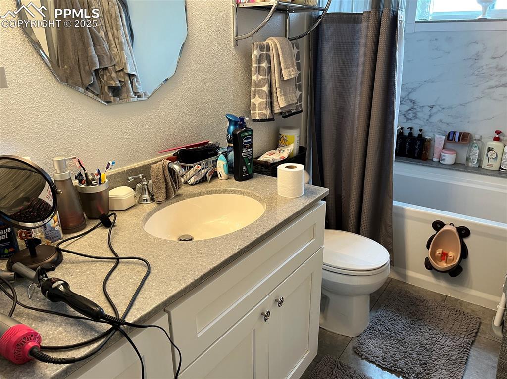 Image 14 of 17: Bathroom with a textured wall, vanity, and shower / bath combo